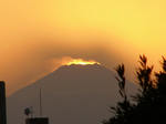 富士山の向こうに太陽が没し、山頂が輝いています